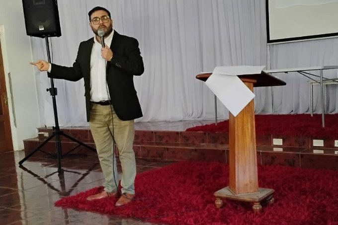 Boris González hablando con micrófono durante una conferencia
