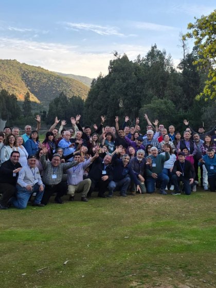 Grupo numeroso de asistentes posando al aire libre al cierre de una jornada