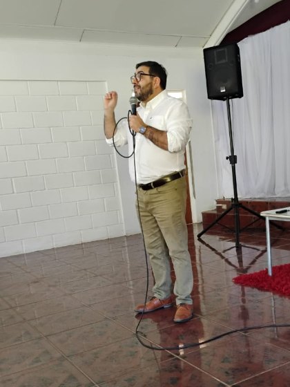 Boris González exponiendo con micrófono durante una actividad presencial