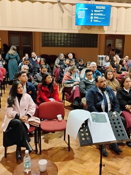 Público sentado siguiendo una charla en un salón